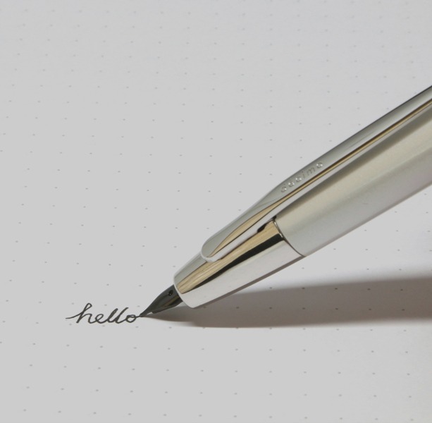 Image of a ballpoint pen scrawling the world hello... Photo by R Mo on Unsplash.