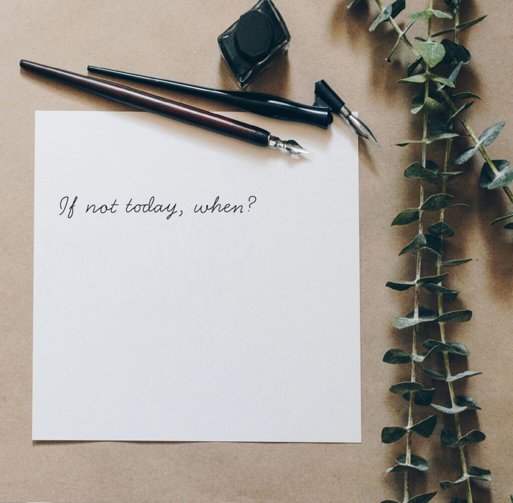 Image of a square piece of paper with two felt tip pens sitting along the top. 'If not today, when?' is written in black cursive font. Green foliage is to the right of the paper. Photo by Kelly Sikkema on Unsplash.